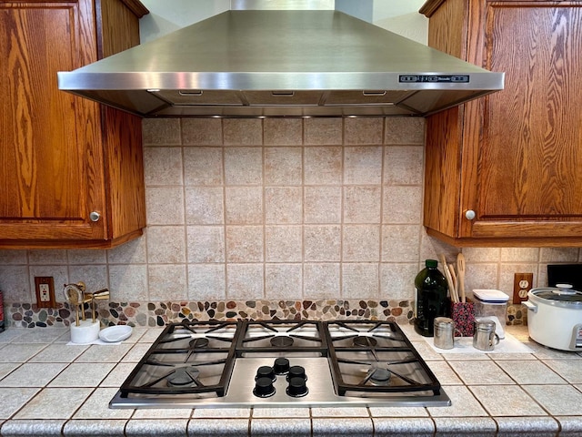 kitchen with tasteful backsplash, island exhaust hood, and gas stovetop