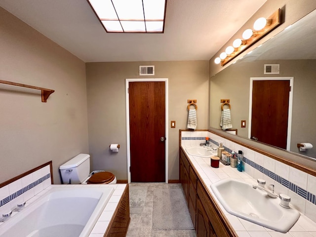 bathroom with tiled tub, vanity, and backsplash