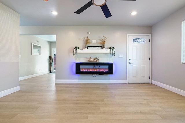 unfurnished living room with ceiling fan and light wood-type flooring