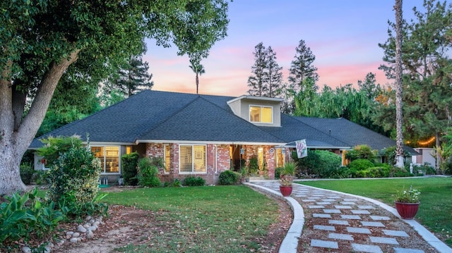 cape cod-style house with a lawn