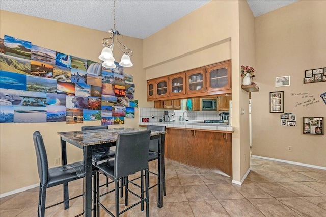 tiled dining room with sink, lofted ceiling, a textured ceiling, and an inviting chandelier