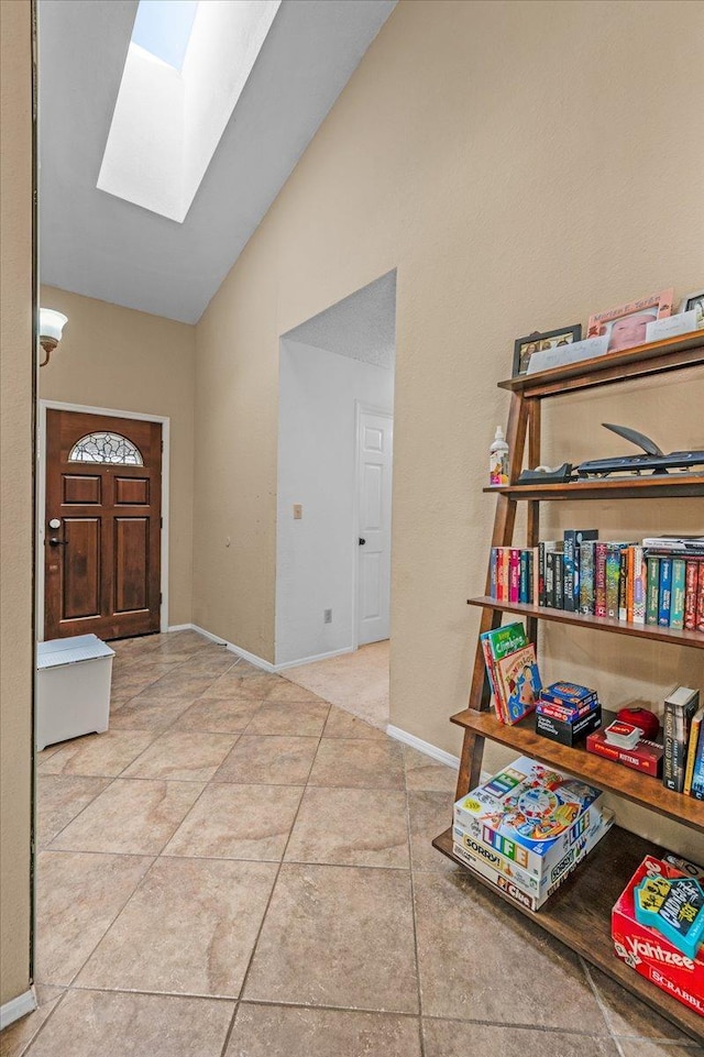 foyer with light tile patterned floors and vaulted ceiling