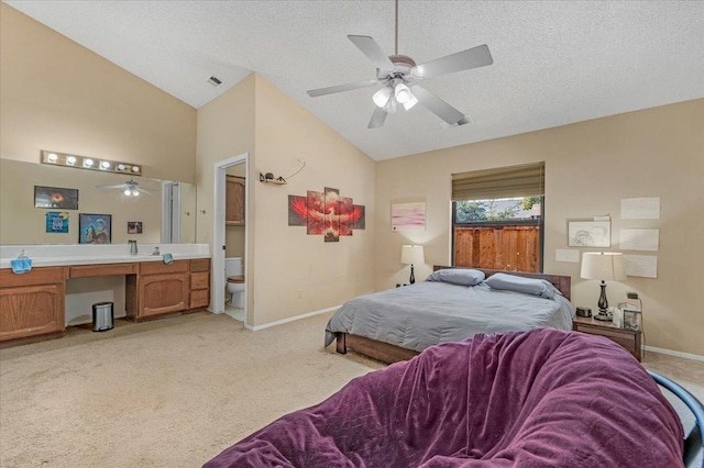 carpeted bedroom with a textured ceiling, ceiling fan, ensuite bathroom, and lofted ceiling