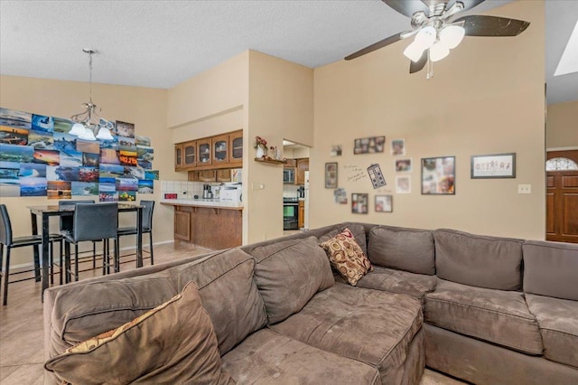 living room with a textured ceiling, ceiling fan, and light tile patterned flooring