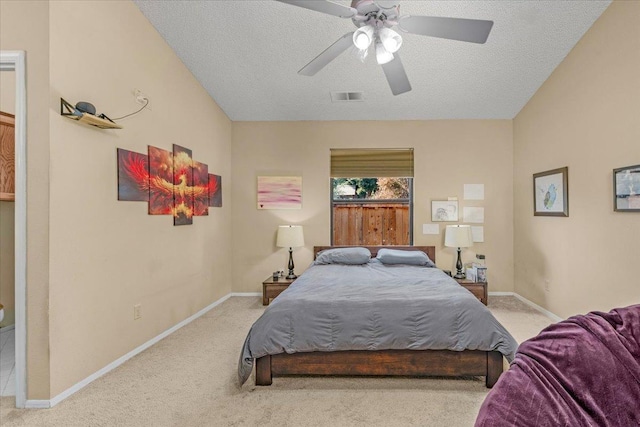 carpeted bedroom featuring ceiling fan and a textured ceiling