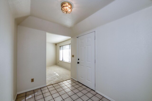 carpeted entryway with lofted ceiling