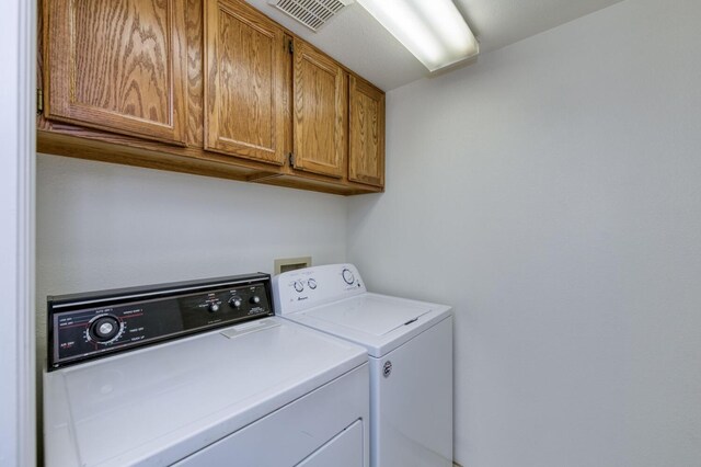 laundry room featuring cabinets and washer and dryer