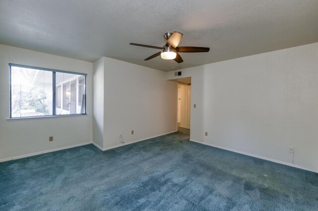 carpeted empty room featuring ceiling fan and a textured ceiling