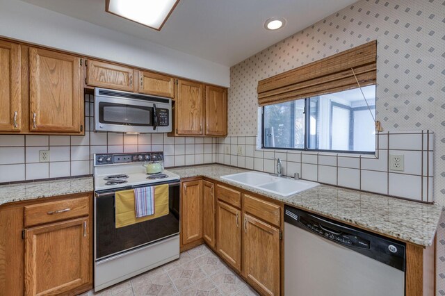 kitchen featuring stainless steel appliances, sink, light tile patterned floors, and decorative backsplash