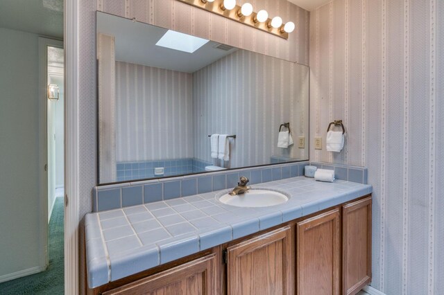 bathroom with vanity and a skylight