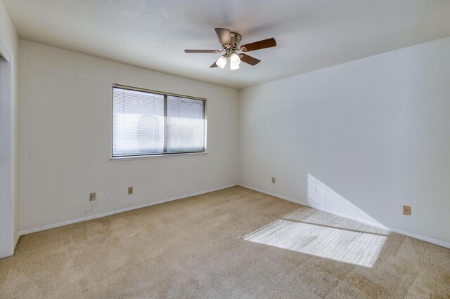 carpeted spare room with ceiling fan