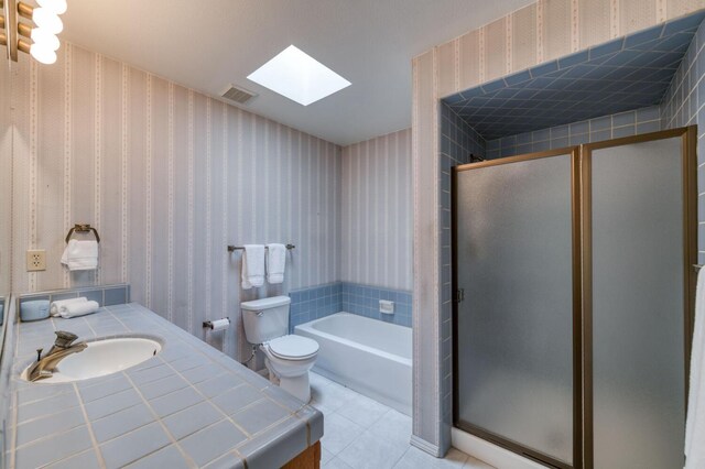 full bathroom featuring toilet, separate shower and tub, tile patterned floors, and a skylight