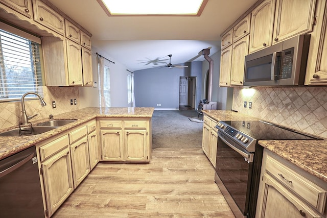 kitchen featuring sink, ceiling fan, decorative backsplash, appliances with stainless steel finishes, and kitchen peninsula