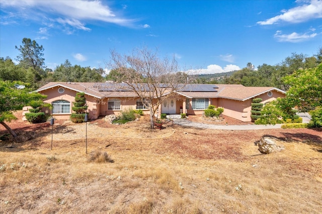 ranch-style house featuring solar panels