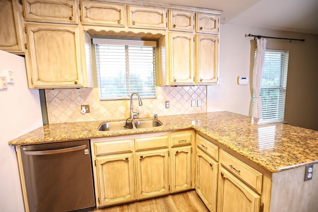 kitchen featuring dishwasher, sink, light stone countertops, light wood-type flooring, and kitchen peninsula