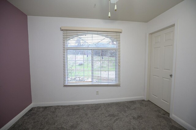 spare room with dark carpet