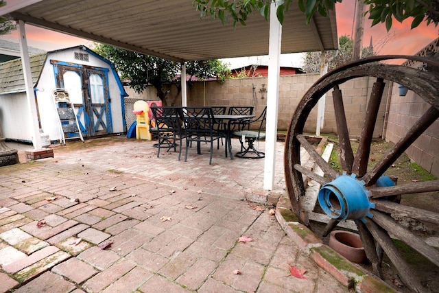 patio terrace at dusk featuring a storage unit