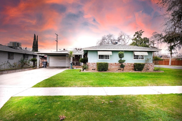 ranch-style house featuring a yard and a garage