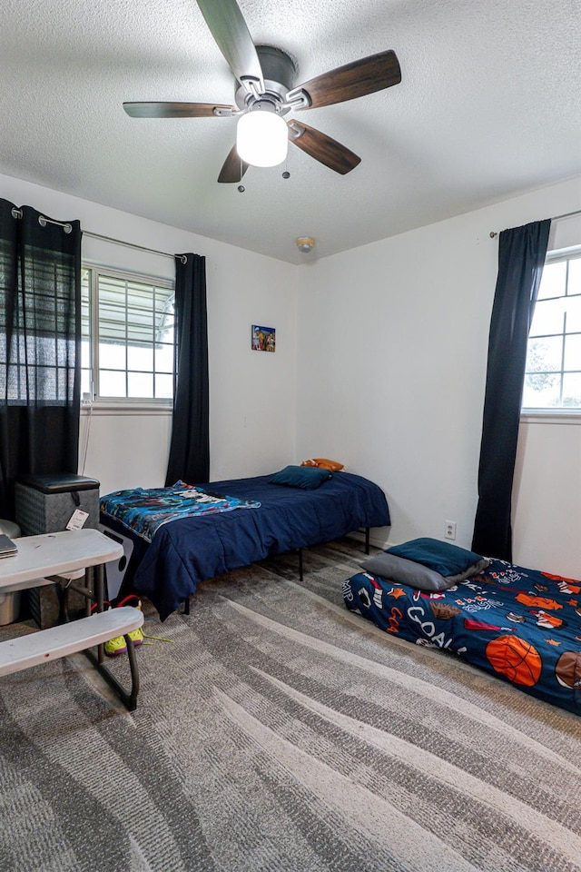 bedroom featuring carpet floors, a textured ceiling, and ceiling fan