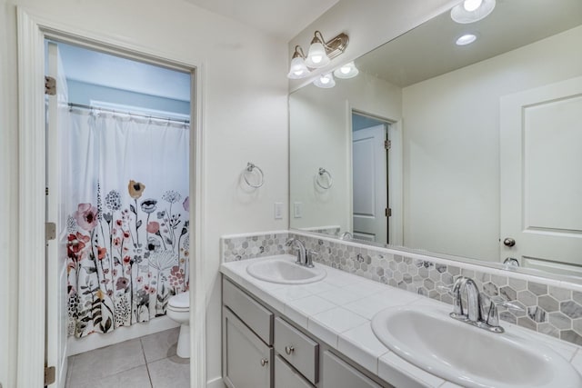 bathroom featuring backsplash, tile patterned flooring, vanity, and toilet