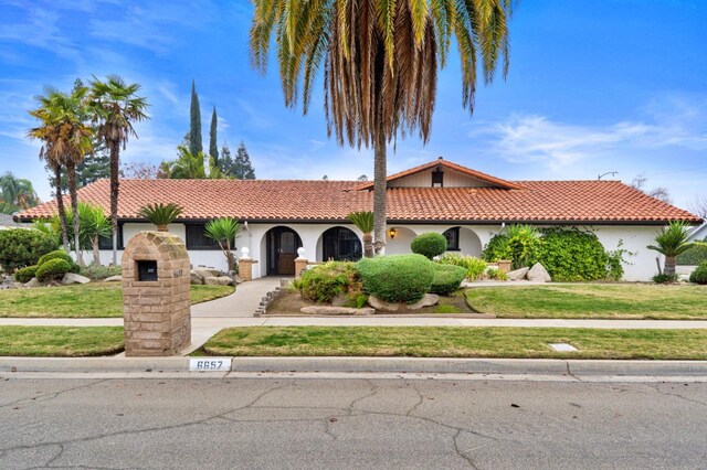 mediterranean / spanish-style home with a front lawn