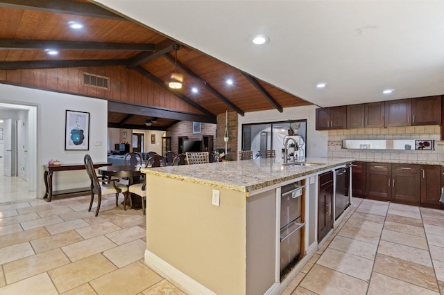 kitchen with sink, wooden ceiling, a kitchen island with sink, and tasteful backsplash