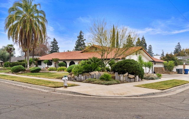 view of front of house featuring a garage, driveway, a tiled roof, and stucco siding