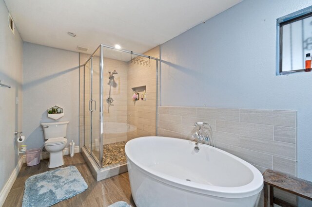 bathroom with hardwood / wood-style floors, separate shower and tub, and toilet