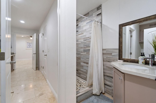 full bath with a stall shower, ceiling fan, and vanity