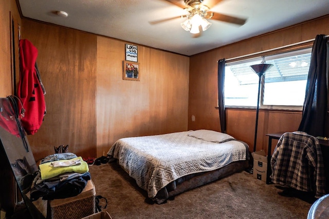 carpeted bedroom with ceiling fan and wooden walls