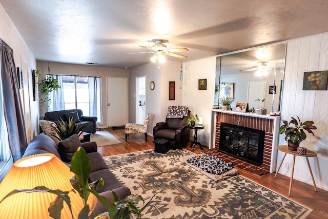 living room with a fireplace, wood walls, and dark hardwood / wood-style flooring