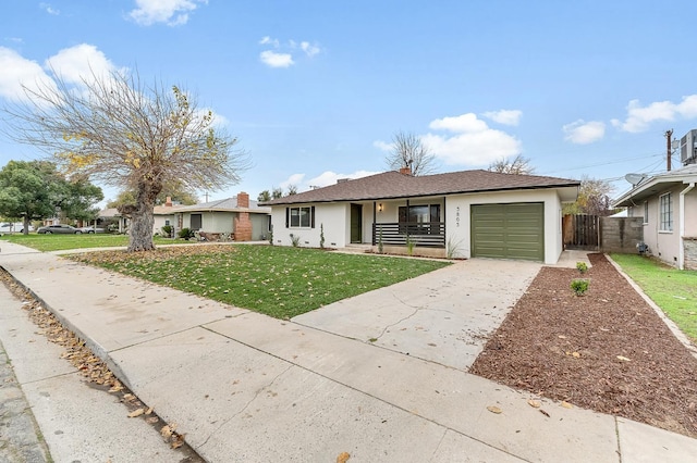 single story home featuring a porch, a garage, and a front lawn