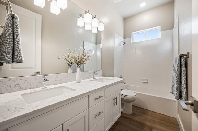 full bathroom featuring toilet, vanity, hardwood / wood-style flooring, and tiled shower / bath combo