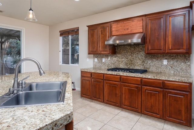 kitchen with backsplash, ventilation hood, sink, pendant lighting, and stainless steel gas stovetop