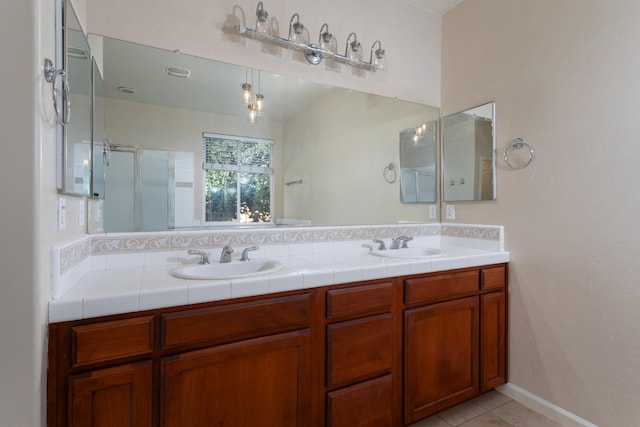 bathroom with tile patterned floors, a shower with door, and vanity