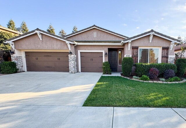 6343 W Babcock Ct, Visalia, CA 93291 - single story home with stucco siding, a garage, stone siding, a front yard, and driveway