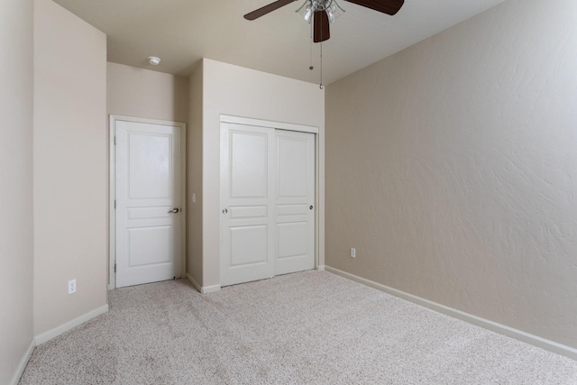 unfurnished bedroom featuring ceiling fan, a closet, and light carpet