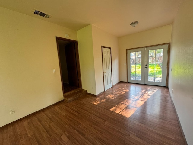 unfurnished room with dark hardwood / wood-style floors and french doors