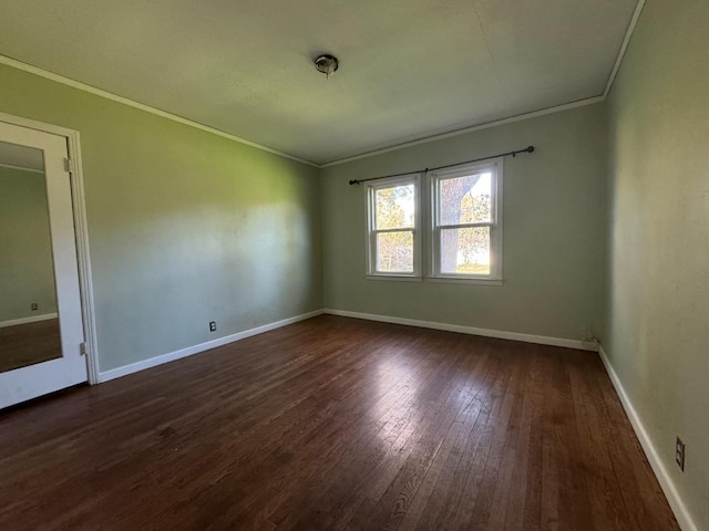 empty room with dark hardwood / wood-style flooring and crown molding