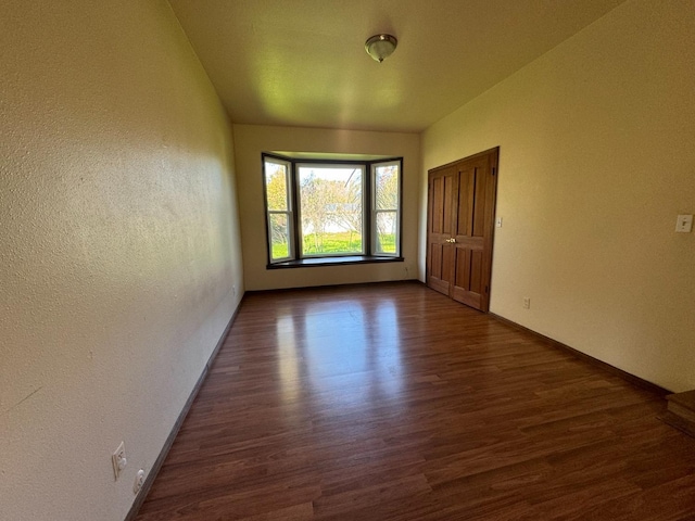 unfurnished room with dark hardwood / wood-style flooring