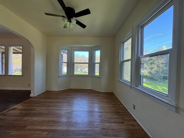 unfurnished room featuring ceiling fan and dark wood-type flooring