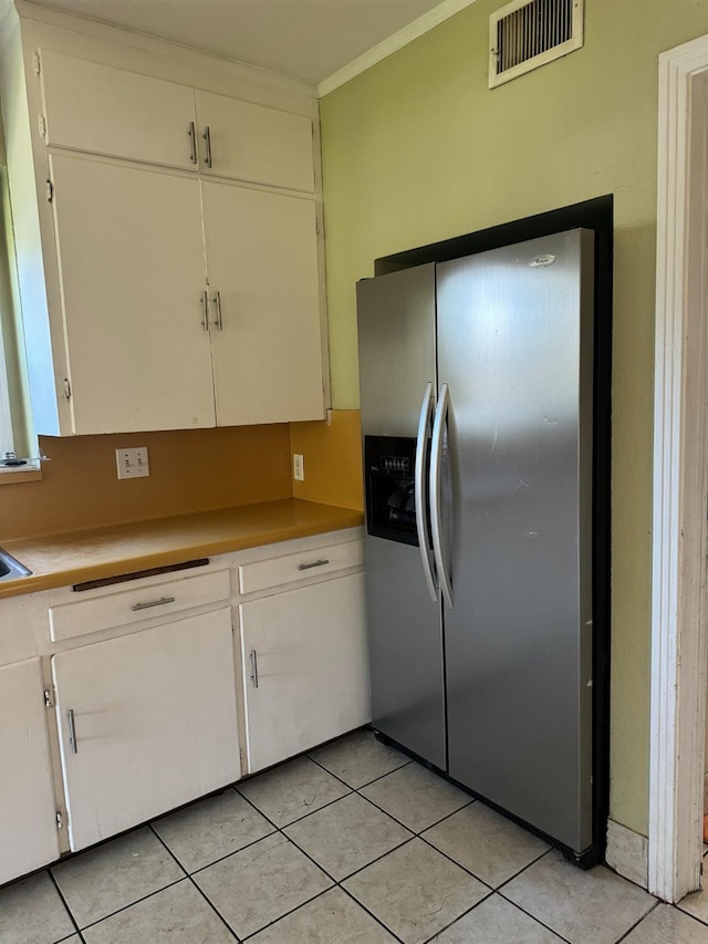 kitchen with white cabinetry, light tile patterned floors, and stainless steel refrigerator with ice dispenser