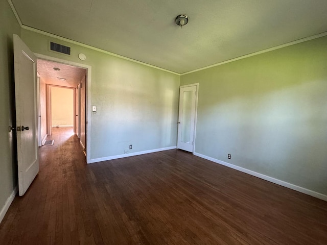 unfurnished room featuring dark wood-type flooring and ornamental molding