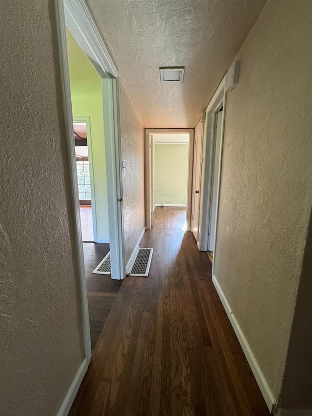 hallway featuring a textured ceiling and dark wood-type flooring