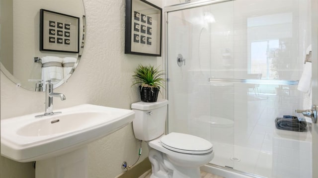 bathroom featuring walk in shower, sink, and toilet