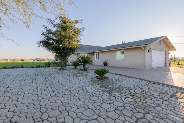 view of front of property with an attached garage, decorative driveway, and stucco siding