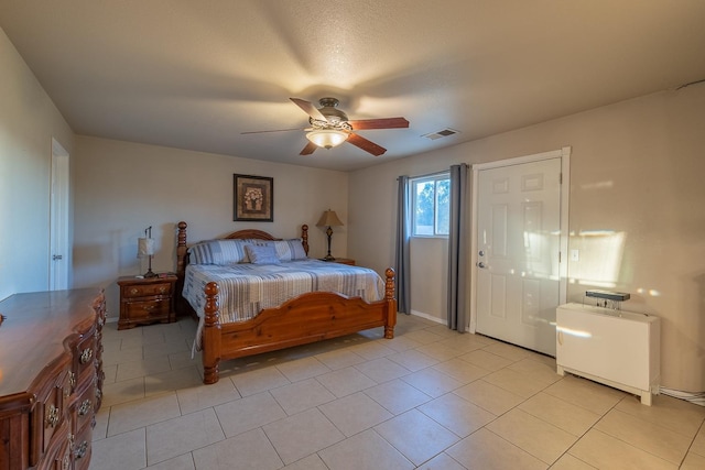 bedroom featuring a ceiling fan, visible vents, and light tile patterned floors