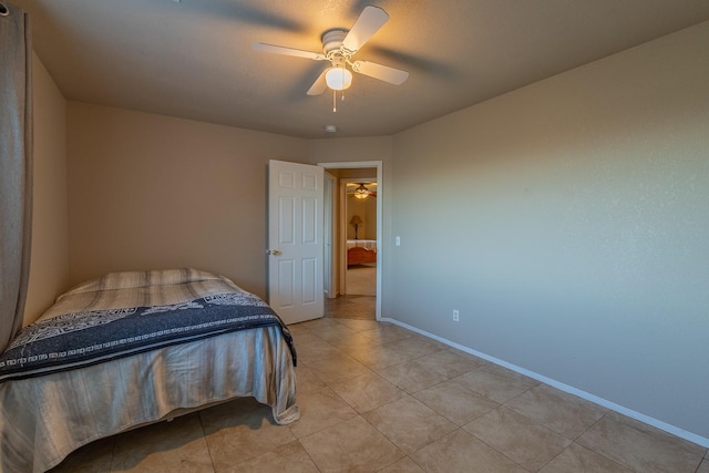 bedroom featuring light tile patterned floors, a ceiling fan, and baseboards