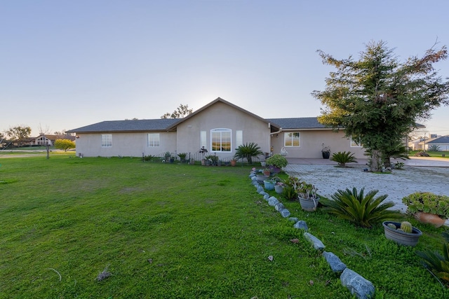 ranch-style house featuring a front lawn, a patio, and stucco siding