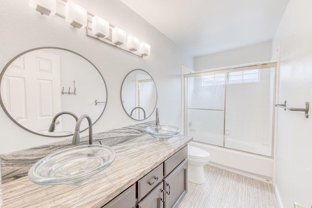 full bathroom with toilet, vanity, and combined bath / shower with glass door